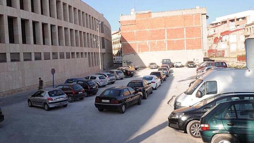 Arriba, parte de los terrenos para un nuevo aulario. Abajo, una estudiante se dirige al único edificio.