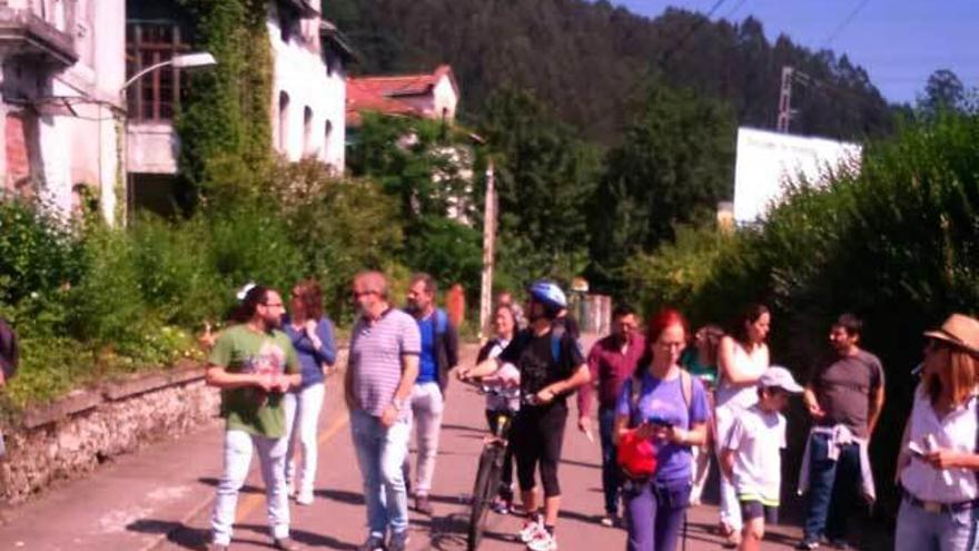 Los participantes en la jornada pasan ante las antiguas residencias de oficiales de la Fábrica de Armas de Trubia, ayer por la mañana.