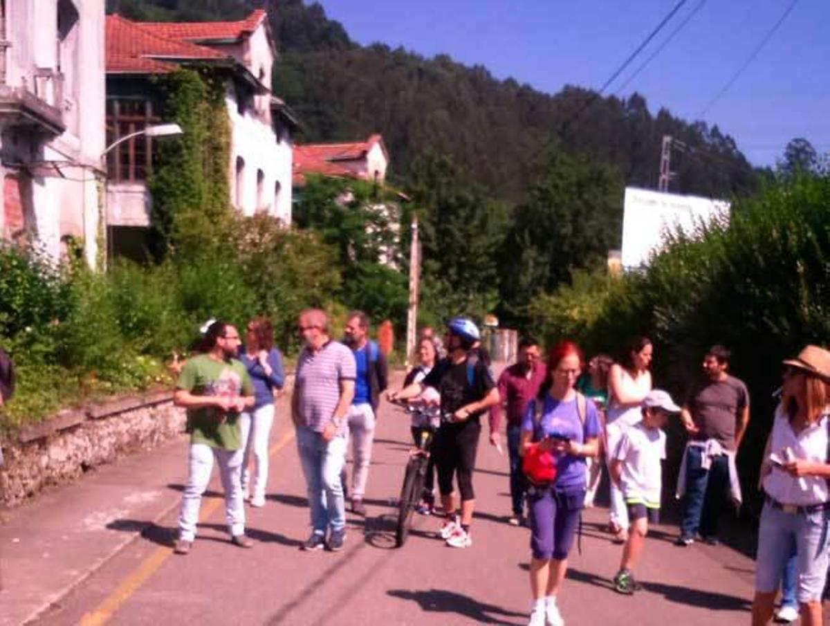 Los participantes en la jornada pasan ante las antiguas residencias de oficiales de la Fábrica de Armas de Trubia, ayer por la mañana.