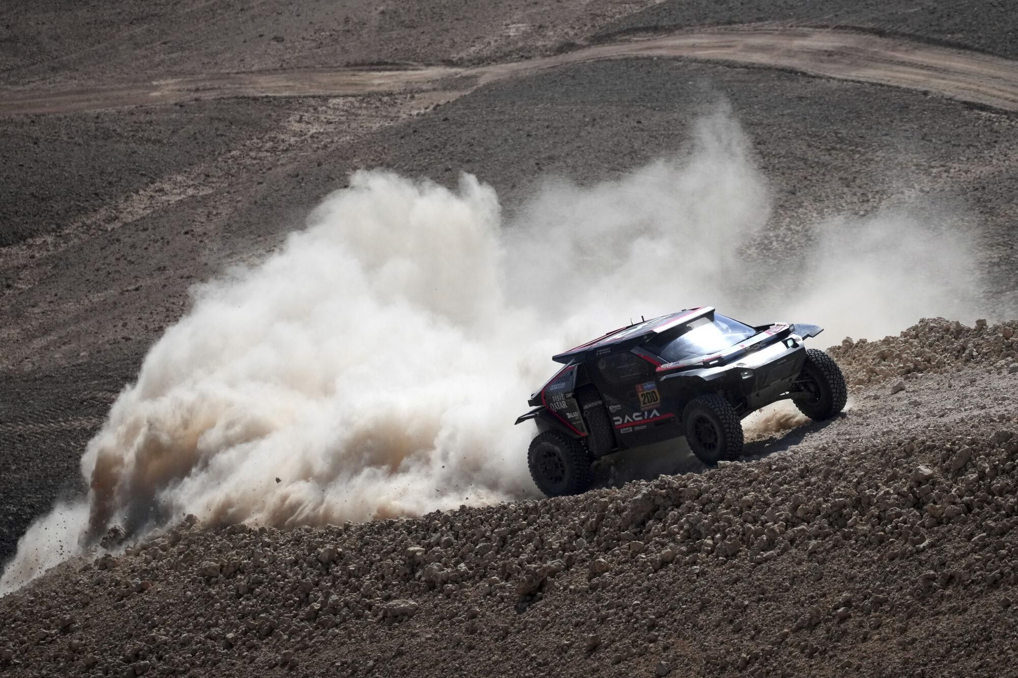 Driver Nasser Al-Attiya, and co-driver Edouard Boulanger compete during the ninth stage of the Dakar Rally between Riyadh and Haradh, Saudi Arabia, Tuesday, Jan. 14, 2025. (AP Photo/Christophe Ena)