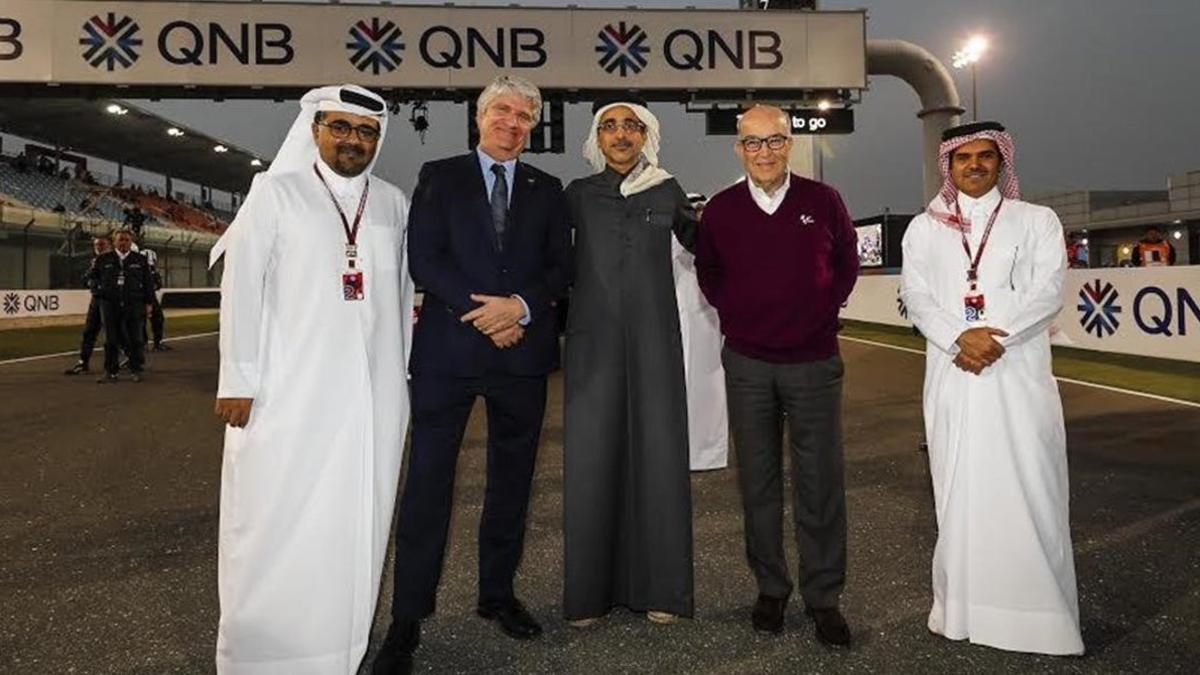 Jorge Veigas y Carmelo Ezpeleta posan, en la recta de Losail, con los máximos responsables del Gran Premio de Qatar.