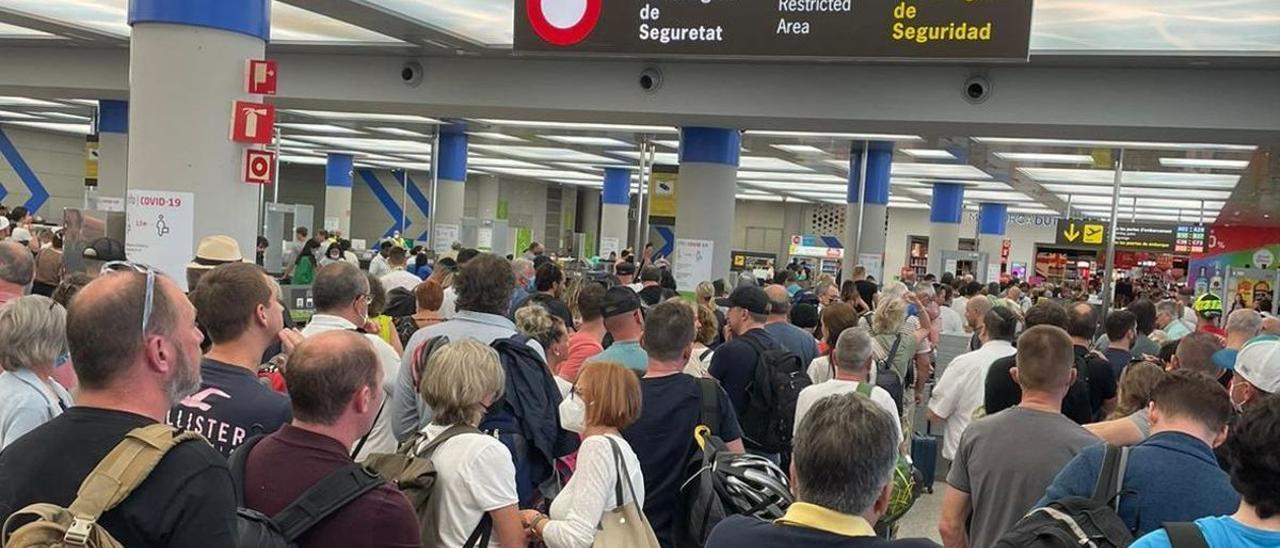 Pasajeros hacen cola para pasar el control de seguridad en el aeropuerto de Palma