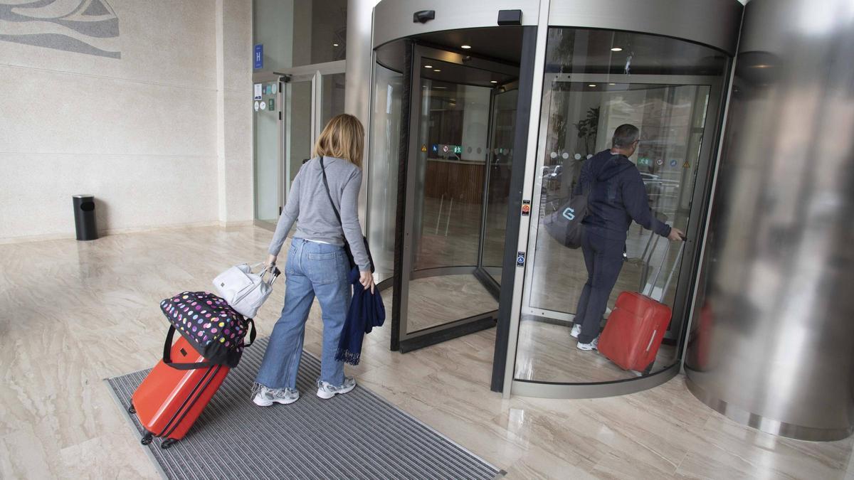 Viajeros entrando en un hotel de Cullera, este año.