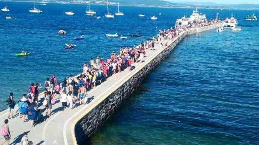 Turistas a la espera de coger el barco en el muelle de Ons. // FDV