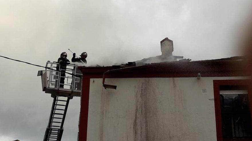 Los Bomberos tratan de sofocar un fuego en un edificio de viviendas en Navia