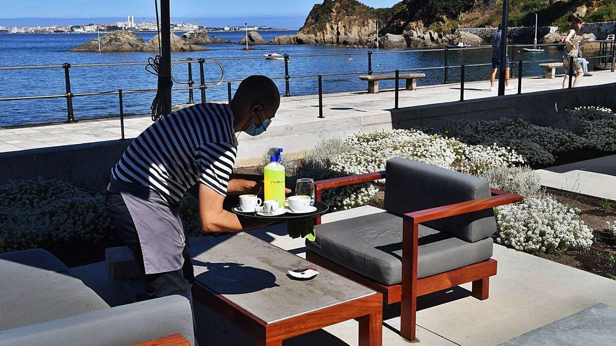 Un trabajador recoge una mesa en la terraza de un establecimiento en Santa Cruz.