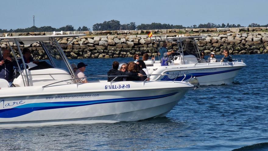 Dos lanchas saliendo del puerto de Vilanova cargadas de peregrinos rumbo a Pontecesures.