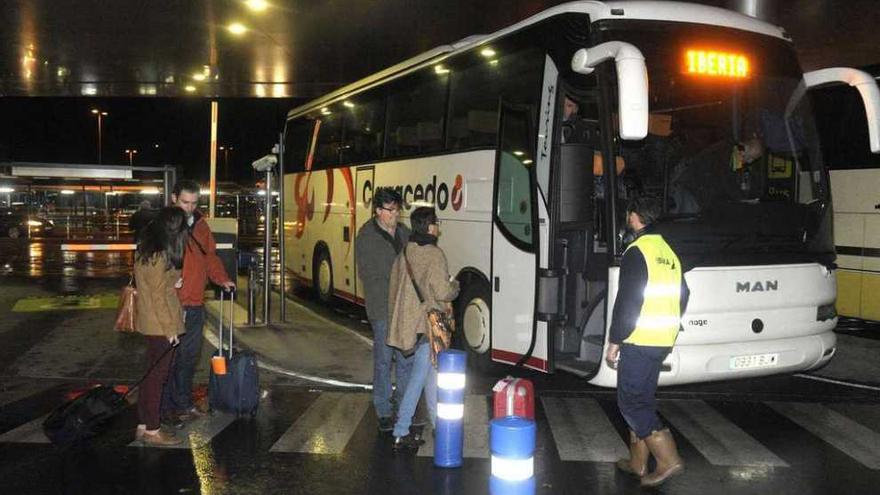 Pasajeros de Alvedro suben a un autobús el pasado mes de diciembre tras el desvío del vuelo que debían tomar.