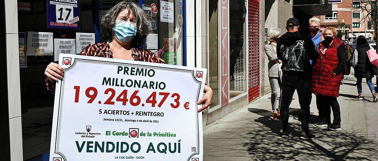 La lotera Amalia López, con el cartel del premio del Gordo de la Primitiva en la calle Río de Oro.