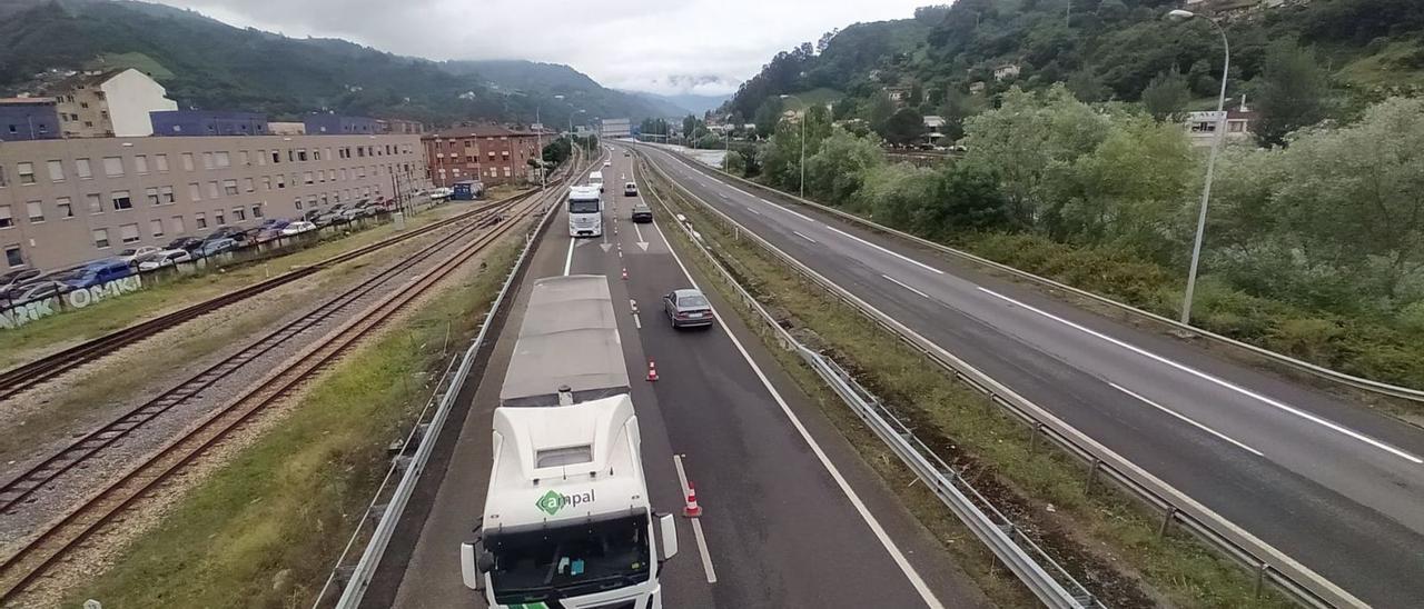 Turismos y camiones, ayer por la mañana, circulando por el tramo afectado por las restricciones, con la calzada en dirección cortada. | D. M