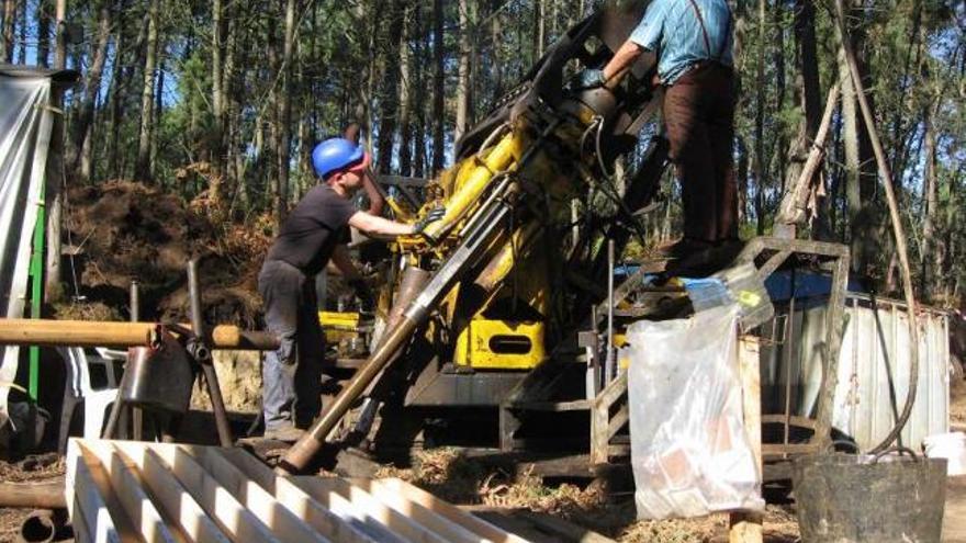 Dos operarios de Rio Narcea Gold Mines trabajan con maquinaria pesada en Corcoesto. / la opinión