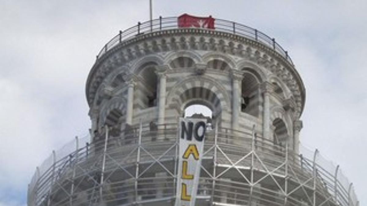 Unos estudiantes despliegan una pancarta en la que se puede leer &quot;No a la reforma&quot; en la Torre de Pisa, hoy.
