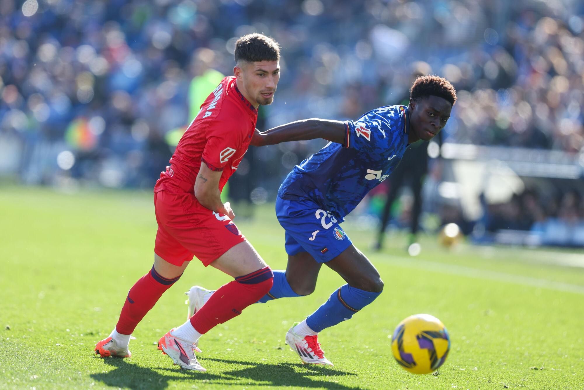 GETAFE (MADRID), 01/02/2025.- El defensa del Sevilla José Ángel Carmona (i) lucha por el balón con el centrocampista del Getafe Coba Da Costa durante el partido de LaLiga que enfrenta al Getafe contra el Sevilla este sábado en el Coliseum en Getafe. EFE/ Kiko Huesca