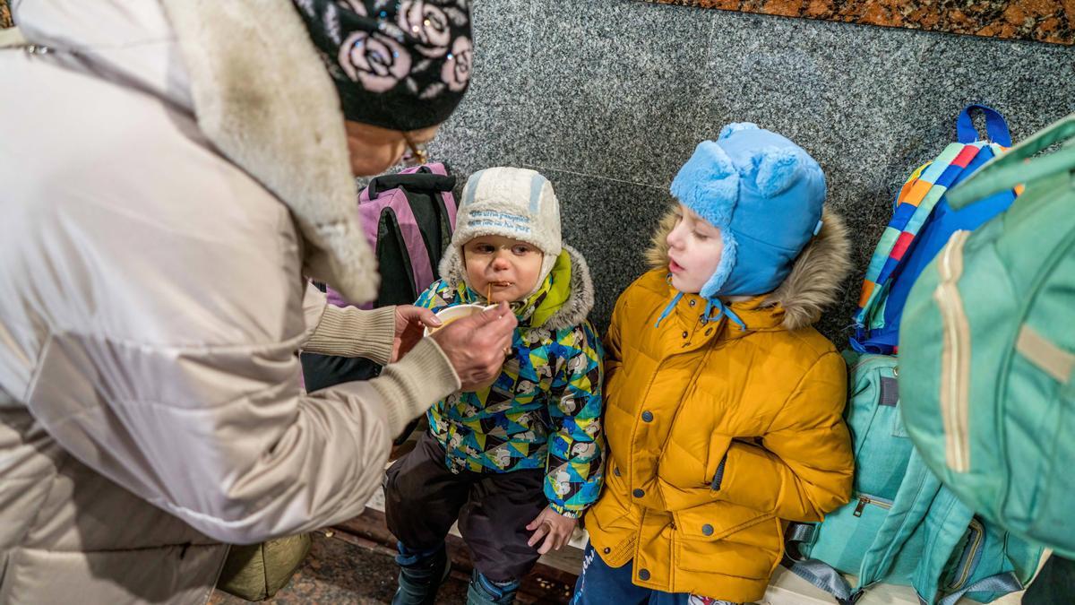 Lviv, Ucrania: una madre alimenta a su hijo en el paso subterráneo de la estación.
