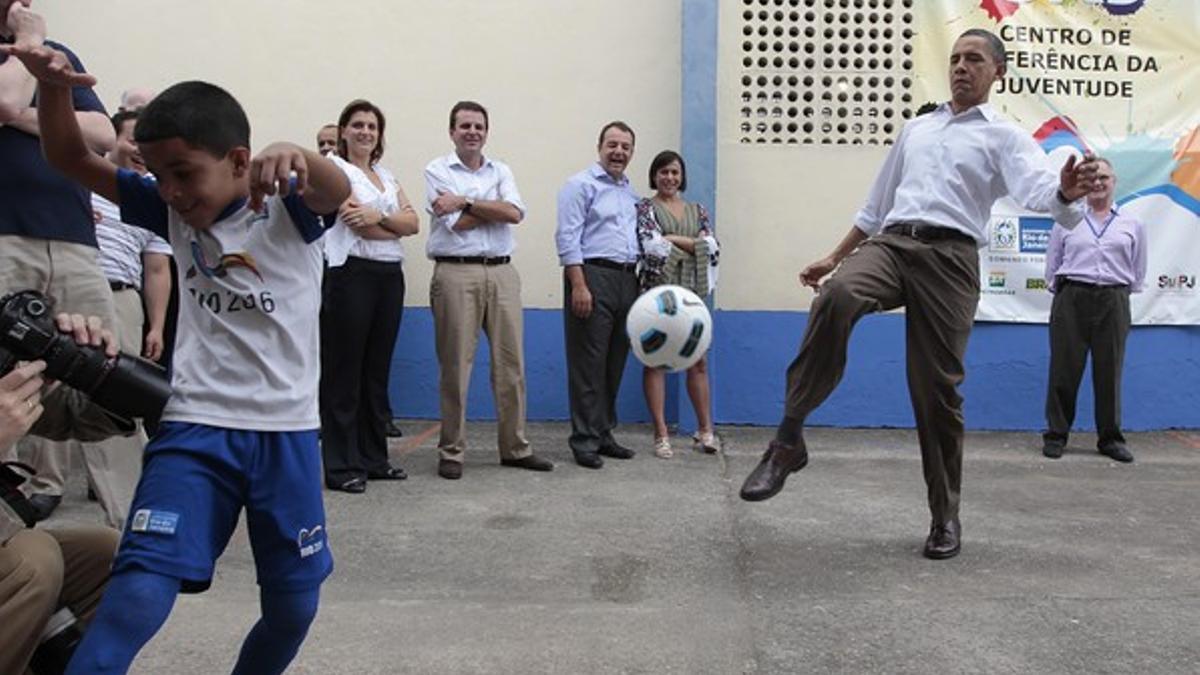 Barack Obama da unos toques a un balón de fútbol, este domingo, durante su visita a la favela Ciudad de Dios, en Río de Janeiro.