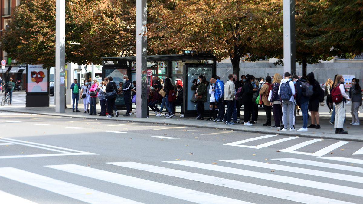 Numerosos usuarios, esperando en una marquesina a que llegue el autobús en un día de huelga.