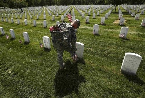 A member of the Third U.S. Infantry Regiment takes part in a "Flags-In" ceremony at Arlington National Cemetery in Washington