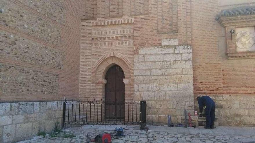 Un operario instala una verja en el Santo Sepulcro para evitar que vecinos orinen junto al templo.