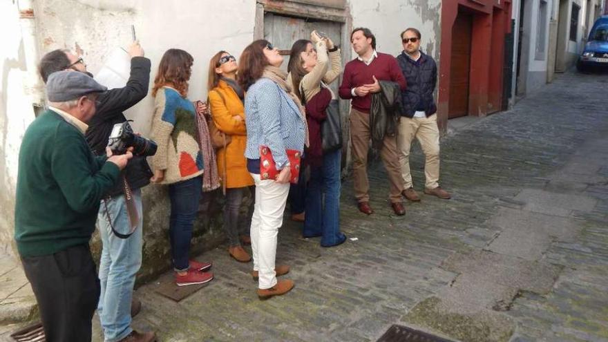 La conselleira saca una foto a una de las casas en ruinas en su visita con el PP de Betanzos al casco histórico