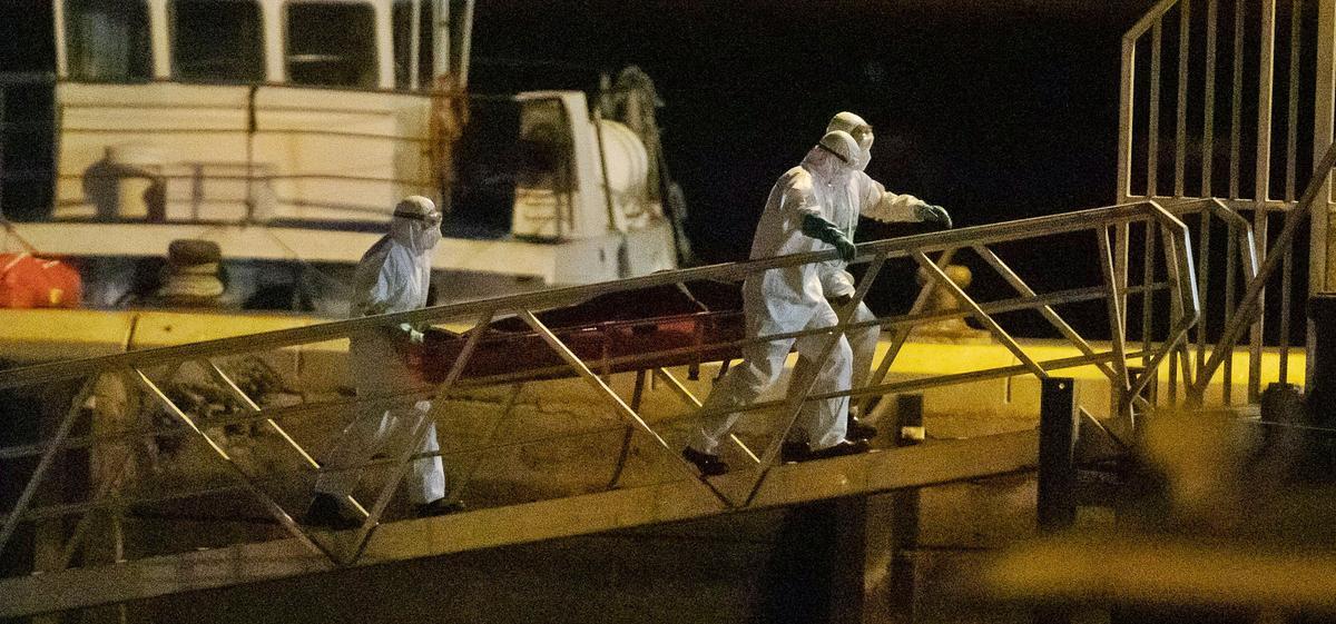 Un grupo de bomberos desembarca uno de los cuerpos de los migrantes hallados al sur de El Hierro. | | ANDRÉS GUTIÉRREZ