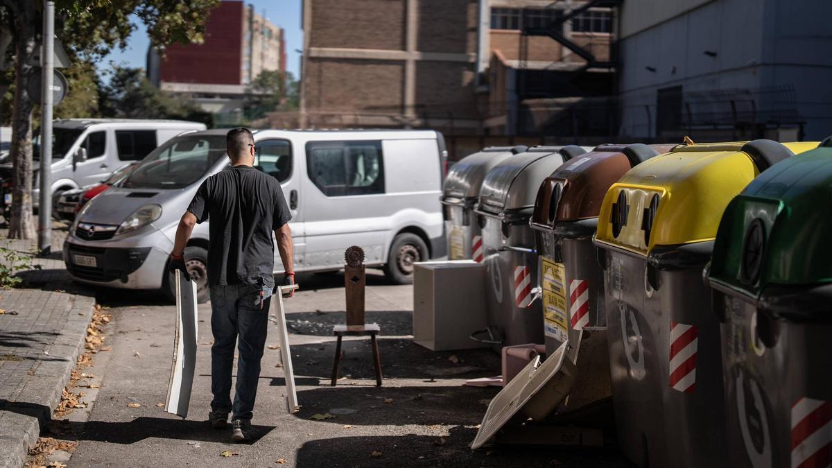 Vecinos y trabajadores del barrio de San Roque de Badalona entre basura y contenedores para ilustrar la aplicación de la segunda tasa de residuos.