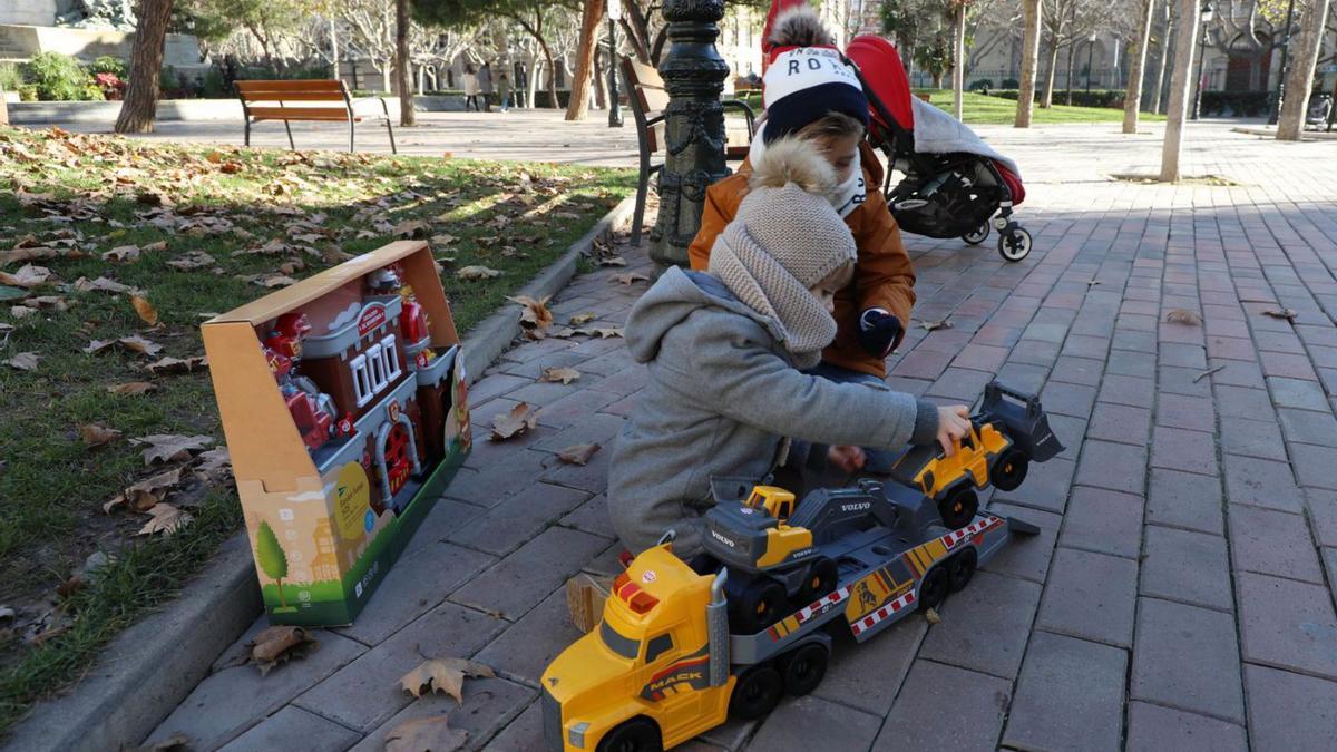 Unos niños estrenan sus regalos en la plaza de los Sitios.  | ANDREEA VORNICU