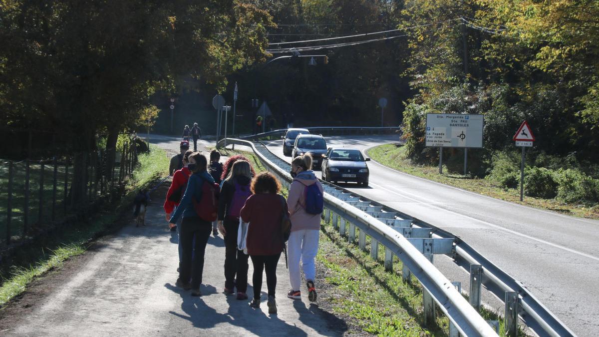 Un grup d&#039;excursionistes camina en direcció a la Fageda d&#039;en Jordà aquest dissabte 24 d&#039;octubre després d&#039;haver aparcat en una urbanització.