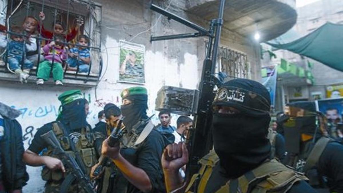 Varios niños observan a militantes armados de Hamás, ayer en Gaza.