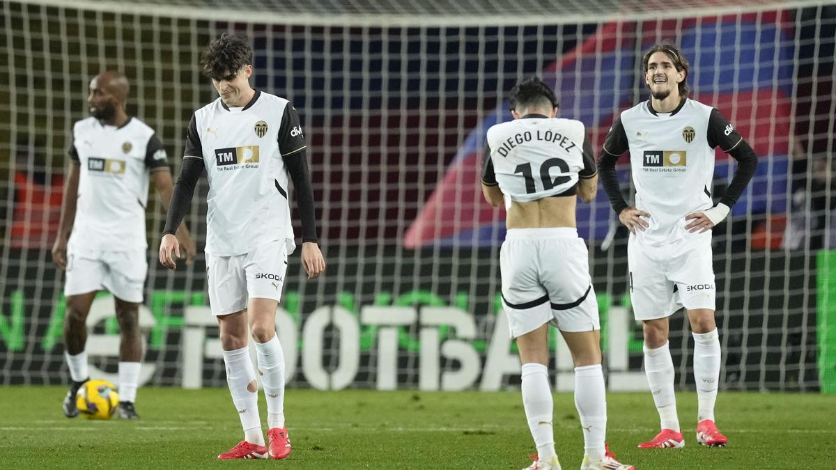 Los jugadores del Valencia CF, cabizbajos en Montjuic tras recibir una dolorosa goleada frente al FC Barcelona en la Liga.