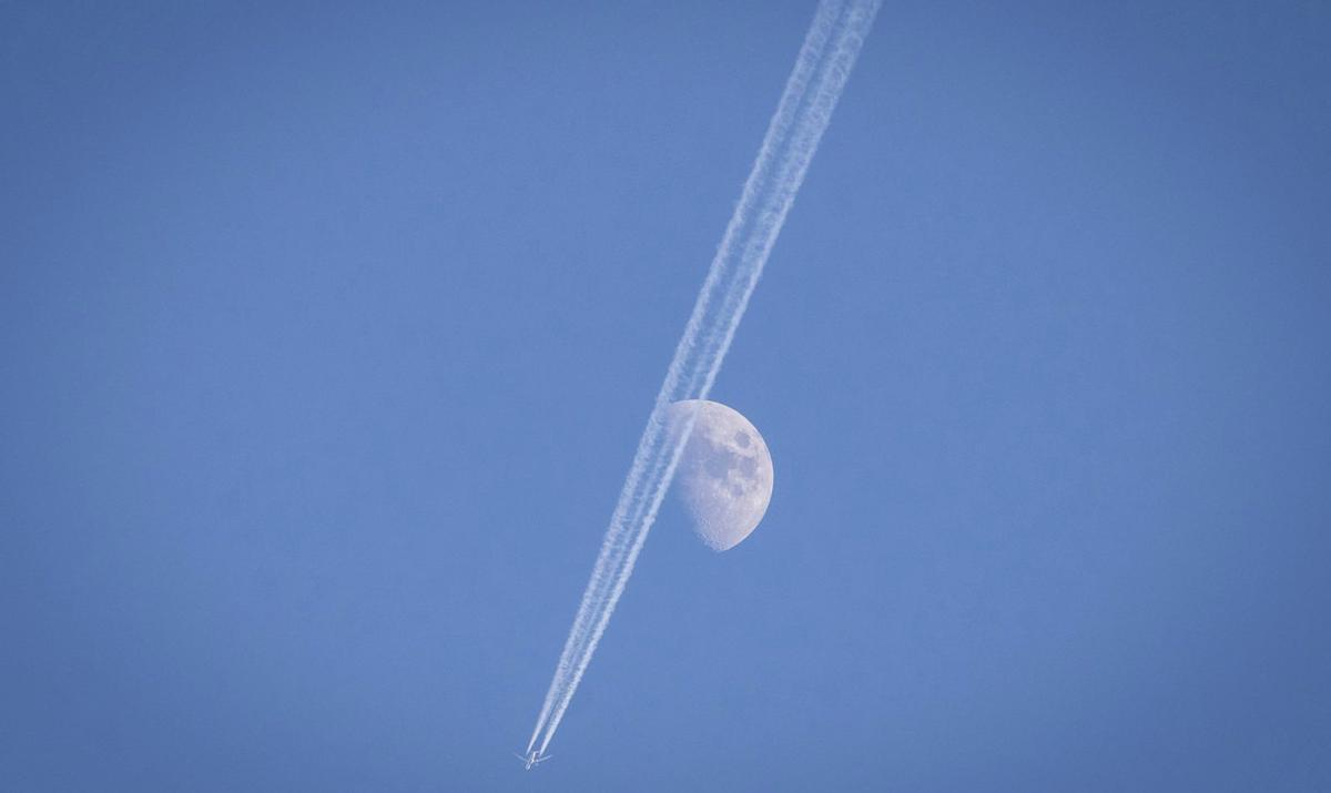 Estela de condensación dejada por un avión a su paso por Eivissa con la Luna de fondo. / VICENT MARÍ