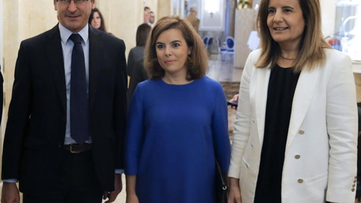 Soraya Sáenz de Santamaría, entre el portavoz del PP, Alfonso Alonso, y la ministra de Empleo, Fátima Báñez, este miércoles en un desayuno informativo.