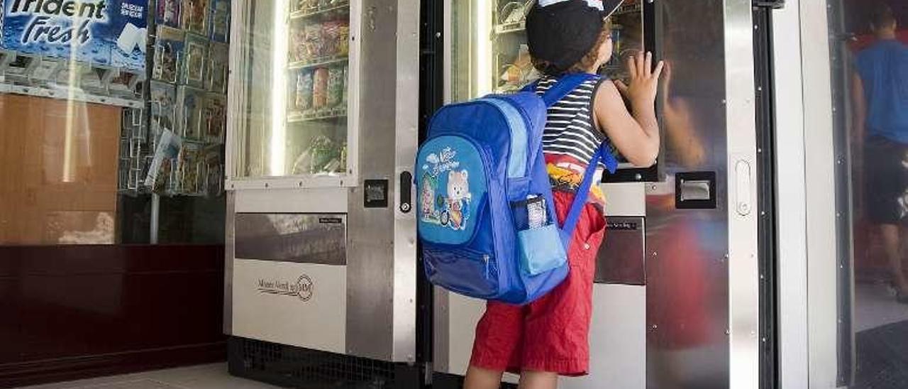 Un alumno ante una expendedora automática en Vigo. // Eli Regueira