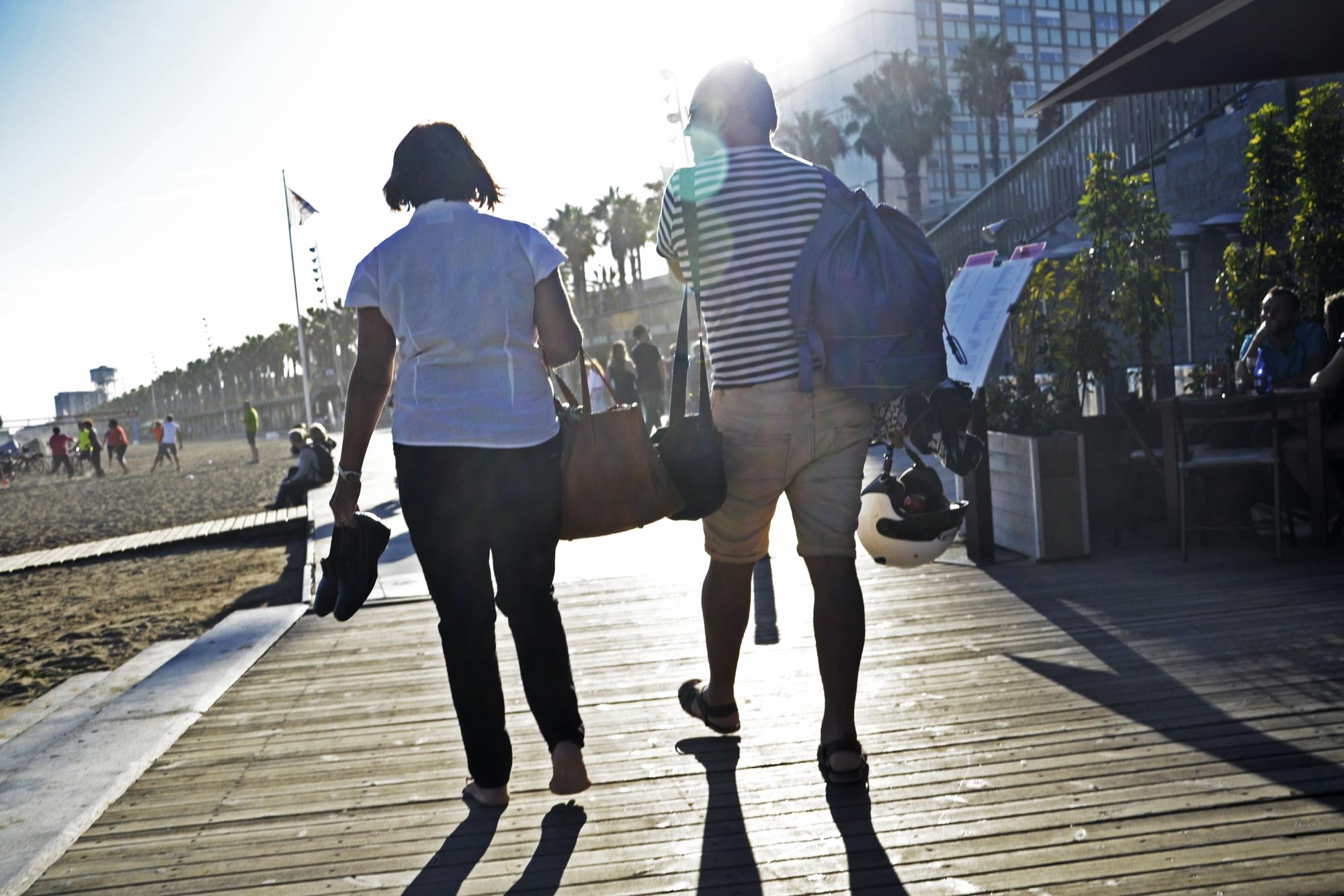 Una pareja pasea por la playa de la Barceloneta