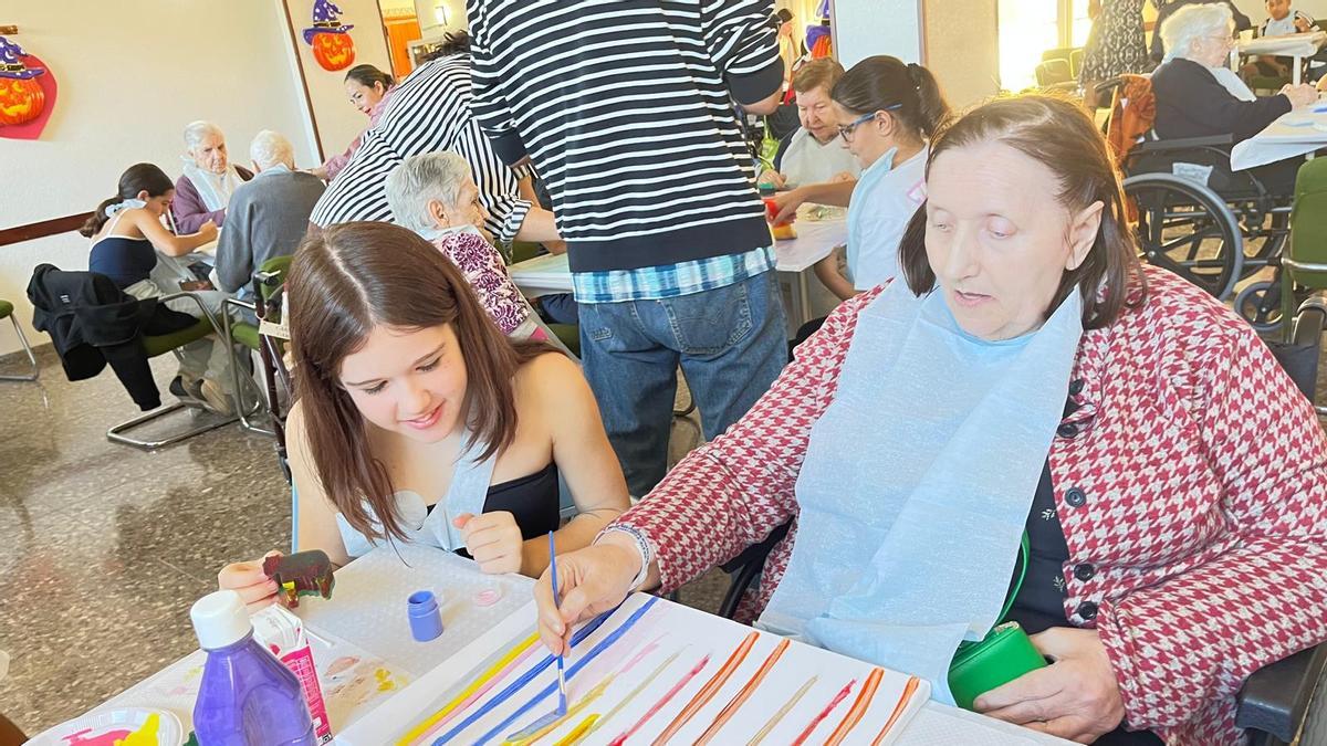 Una alumna del Colegio Cuba de Torrevieja junto a una residente del centro de mayores "Francisco Casanovas" en una de las jornadas de talleres y actividades