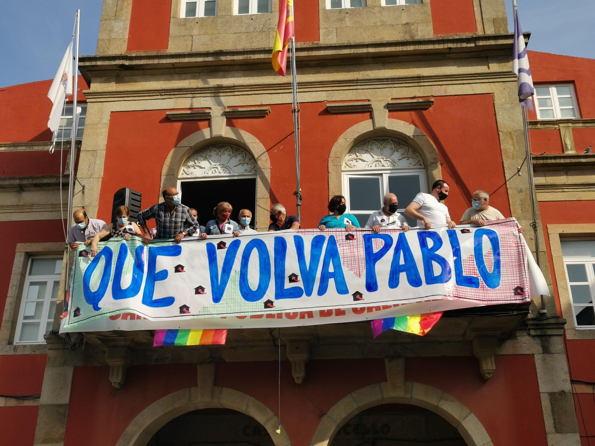 Momento de colocación de la pancarta en el balcón de la casa consistorial pidiendo la liberación del marinero.