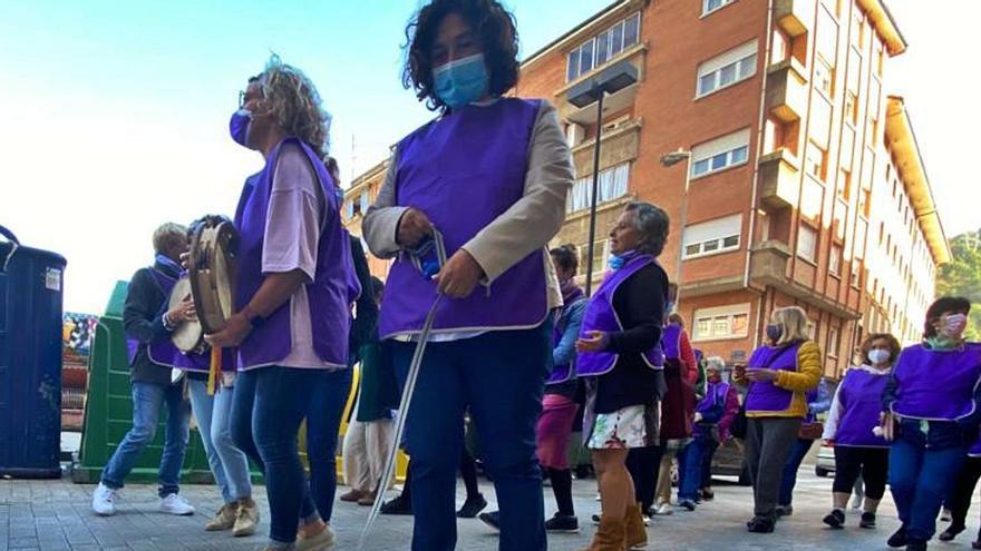 Arriba, asistentes a la marcha en la salida de la Casa de Encuentros de Pola de Lena. Sobre estas líneas, actuación de la agrupación “Nun tamos toes”. | C. M. B.