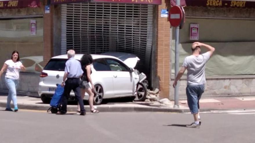 Aparatoso accidente en Laviana: un coche se empotra contra una tienda de deportes