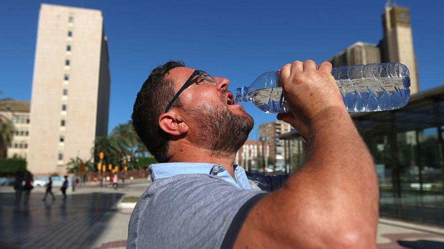 Un hombre se refresca en un día caluroso en Málaga.