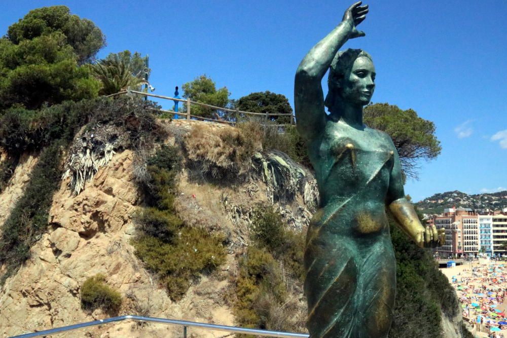 Lloc on ha saltat un turista a Lloret de Mar: al fons hi ha el mirador des d'on estava i en primer pla l'escultura de la dona marinera que hi ha a baix en el camí de ronda.