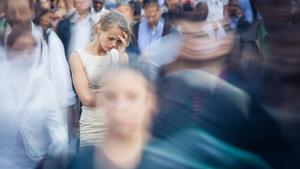 Mujer joven deprimida que se siente sola en medio de una multitud de personas en una gran ciudad