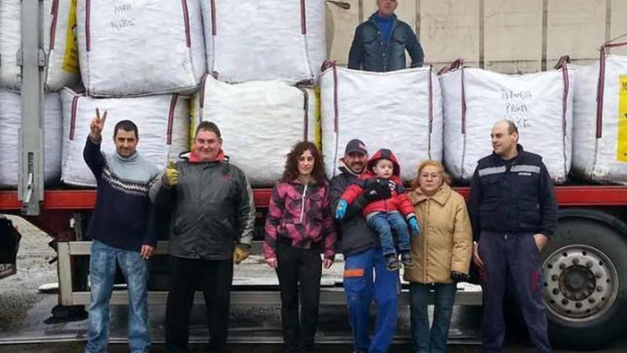 Carlos Gomes, padre de Kike, hace la señal de la victoria acompañado de colaboradores y familiares junto al camión que cargaron ayer con los 5.400 kilogramos de tapones para enviarlos a León.