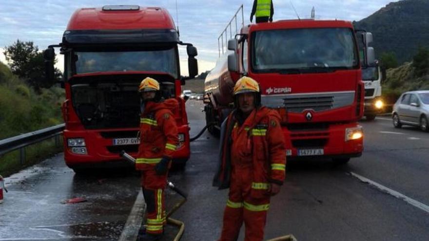 Los bomberos trasvasan el gasoil derramado.