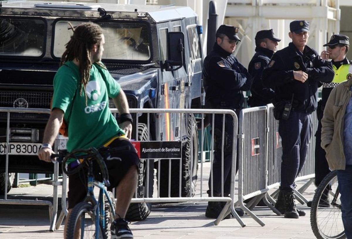 Un jove observa agents de la Guàrdia Urbana i la Policia Nacional als voltants de l’Hotel Arts.