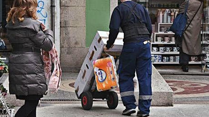 Un trabajador transporta un pedido de un supermercado.