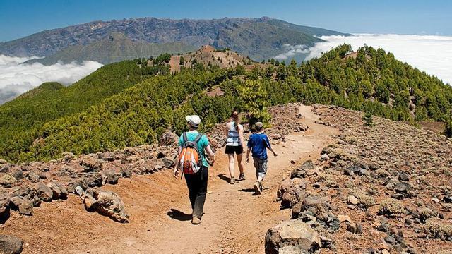 Tres turistas practican senderismo en La Palma.