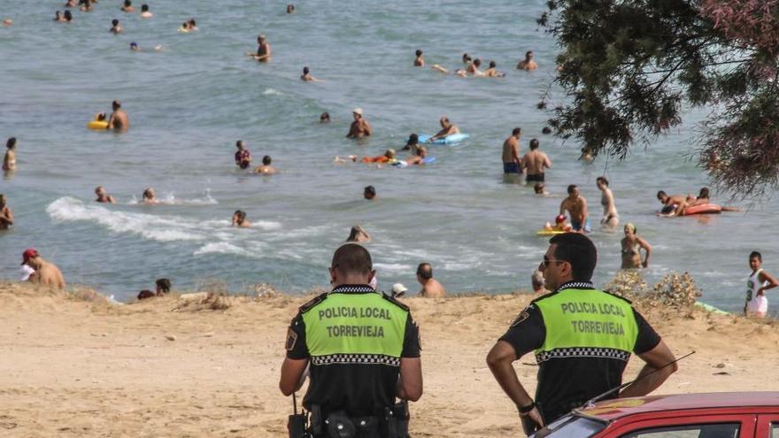 Dos agentes de la Policía Local de Torrevieja observan a unos bañistas