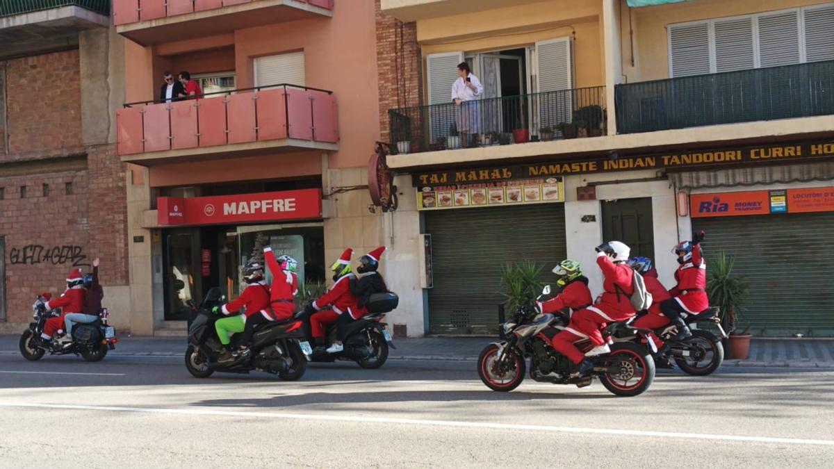 Els motoristes disfressats de Pare Noel passant per l'avinguda Dalí