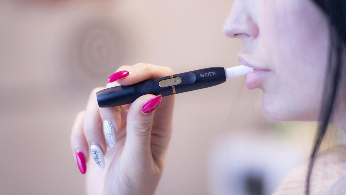 Una mujer fumando tabaco calerntado