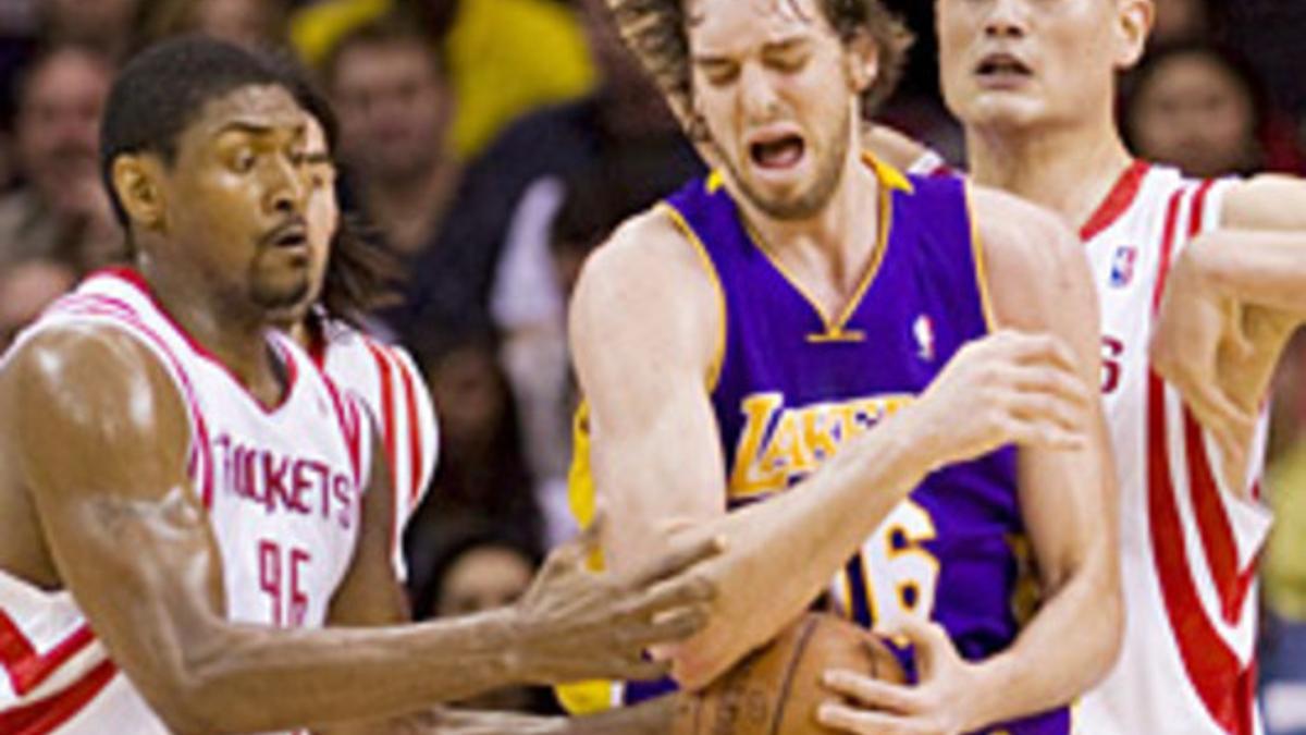 El jugador de los Lakers Pau Gasol disputa un balón con Ron Artest y Yao Ming, de los Rockets.
