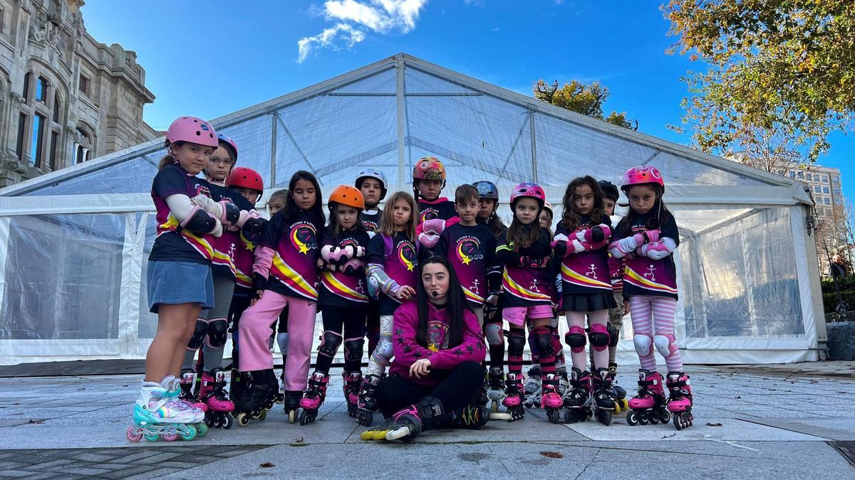 Los niños y su profesora, ante la carpa de la futura pista de plástico de esta Navidad.